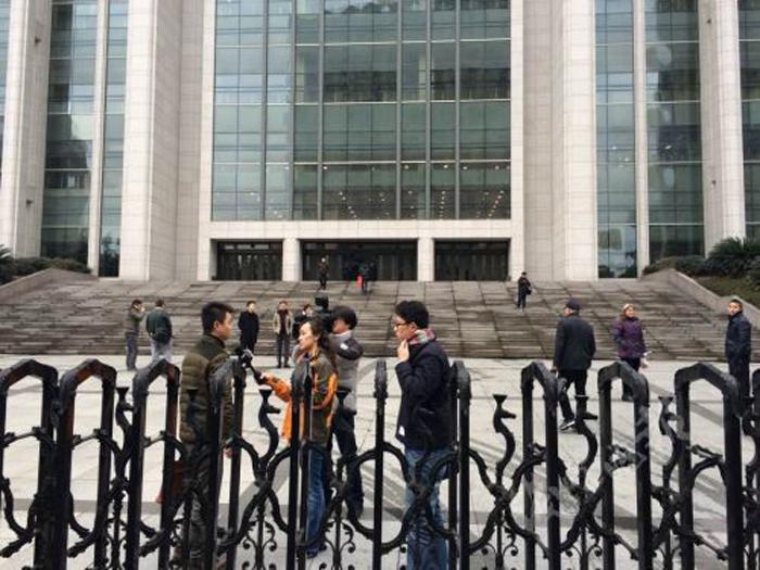 图为杭州市中级人民法院门前，媒体正在采访。