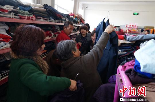 “爱心超市”运营首日,受助居民争相挑选衣服。 杨颖 摄 “爱心超市”运营首日,受助居民争相挑选衣服。 杨颖 摄